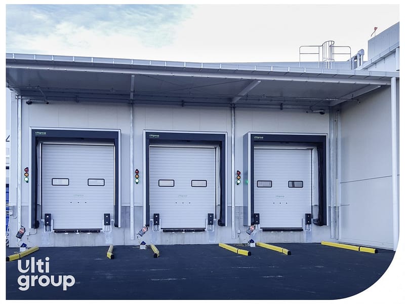 Three insulated loading dock doors with seals and yellow wheel guides.